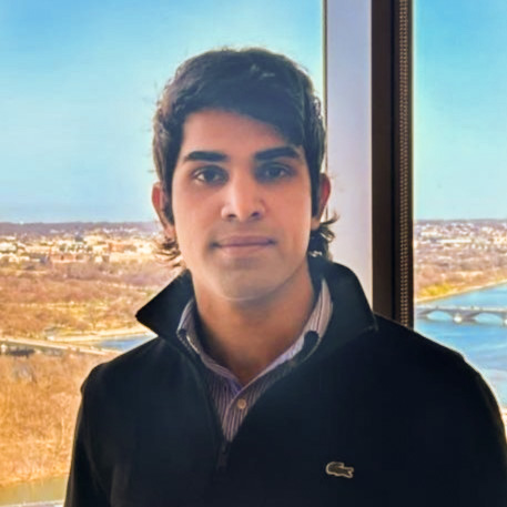 Headshot of Karan Takhar, a black hair man wearing a Lacoste sweater.