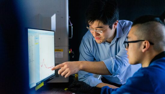 Two scientists analizing a graph in a compute screen.