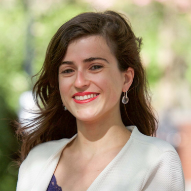 Portrait of Helene Beneviste, a brown hair woman wearing earrings and smiling at the camera.