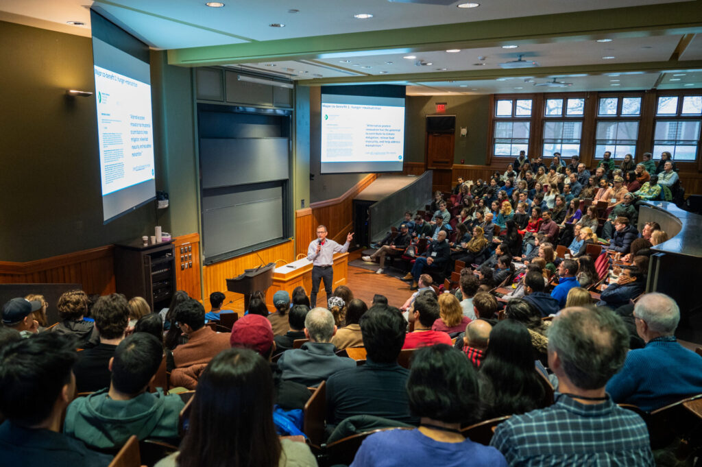 a guest speaker addresses a large lecture hall of food 4 thought festival participants