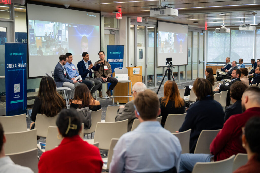 Speakers sit at the front of the room during a Green AI Summit panel session